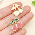 Pink enamel cherry pendant charm with golden base held in hand for DIY jewelry making - Enamel Cherry Charm (23438)