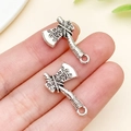 Pair of antique silver axe pendants for DIY crafts shown on fingertips for scale - Antique Silver Axe Style (15835)