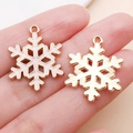 Golden and white enamel snowflake charms for DIY Christmas jewelry making held by hand - Pink Christmas Snowflake Slice Style (24974)