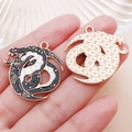 Handheld macro view of a dragon charm with black and white enamel in golden finish - Black Enamel Moon Long Dragon Style (19345)