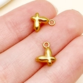 Polished gold butterfly pendant for DIY jewelry making shown on finger for scale - Butterfly Style (T3105)