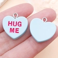 Light blue heart charm with Hug Me text held in hand for size reference - Light Blue Hug Me (SN16422)