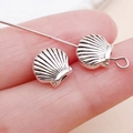Antique silver shell spacers for DIY jewelry making shown against hand for size reference - Ocean Shell Spacer Bead (15976) / 1 Piece (7x7mm) / Antique Silver