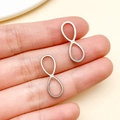 Pendientes de acero inoxidable con signo infinito mostrados para escala de tamaño - Estilo Símbolo Infinito Mediano (T1807) / Paquete de 1 Pieza (0.7x2.0x0.1cm) / Color acero