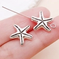 Antique silver starfish spacer bead for DIY jewelry making shown on a fingertip - Ocean Starfish Straight Hole Spacer Bead (24713)