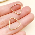 Minimalist gold-plated hollow triangle earring components held for size reference - Rounded Triangle (T1864) / Gold