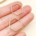 Gold plated stainless steel hexagonal jewelry connectors shown on fingers for scale - Gold