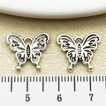 Pair of antique silver hollow butterfly charms for DIY jewelry making next to a ruler - Antique Silver Butterfly (22325)