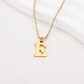 Detailed view of gold-plated letter E pendant with polished venetian chain on white steps - Letter E (BJGN0271) / Gold
