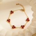 Detailed macro view of gold-plated clover bracelet with ruby red heart-shaped stones - Heart-Shaped Style (BJGB0210) / Red / Bracelet