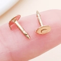Coppia di chiusure a farfalla in metallo dorato mostrate sulla punta di un dito - Oro KC (8x4.8mm)