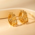 Macro detail of triple-layered golden heart-shaped hoop earrings with polished finish - Heart Hoop Earrings (BJGE0856) / Gold