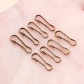 Eight bronze pear-shaped safety pins in hand showing scale for DIY jewelry making - 4x13mm / Antique Bronze