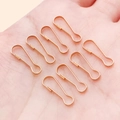 Eight rose gold pear-shaped safety pins made of metal held in hand for jewelry DIY - 6x16mm / KC Gold