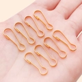 Polished golden pear shaped metal safety pins held in hand for DIY jewelry and crafts - 7x22mm / Gold