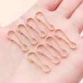 Rose gold pear-shaped safety pins for jewelry making held in hand for scale - 7x22mm / KC Gold