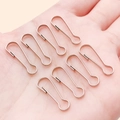 Seven rose gold gourd-shaped safety pins on palm for DIY jewelry and keychains - 7x22mm / White K