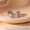 Detailed macro view of silver feather leaf ring on a minimalist ceramic tray - Feather Wrap Style (6) / Steel