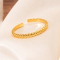 Détail macro d'une bague ajustable dorée à texture torsadée sur tissu de soie blanc - Style Corde Torsadée (#0071)