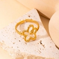 Gros plan détaillé d'une bague fleur évidée dorée sur un support en pierre texturée - Style Fleur Ajourée Minimaliste (#0120)