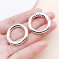 Zwei silberne Federringe aus Metall für DIY-Schmuck und Taschenzubehör in der Hand - AD 28mm ID 19mm / Hellsilber (28mm)