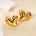 Close-up of 18K gold plated heart stud earrings on a beige stone decorative stand - Gold Voluminous Asymmetric Heart (#0121J)