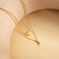 Double-layered gold necklace with smooth heart pendant and J-shaped initial charm - Letter J