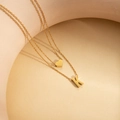 Double layered gold necklace featuring a minimalist heart charm and letter K pendant - Letter K