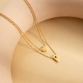 Close-up of double-layer gold necklace featuring a heart charm and letter P pendant - Letter P