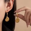 Detail of vintage matte gold snail shell pendant earrings worn by a model - Conch Earring