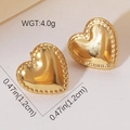 Gros plan de boucles d'oreilles cœur dorées avec fini poli et bordure perlée - Style Cœur Perlée (#0986)