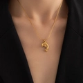 Polished golden dolphin pendant necklace shown on a model with elegant black attire - Dolphin Necklace