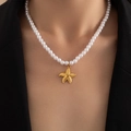 Detail of natural pearl necklace with golden starfish pendant on a black suit jacket - Artificial Pearl Starfish (BJGN0397)