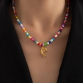 Detalle de collar boho de cuentas de colores con colgante de delfín dorado en modelo - Delfín (Collar Cuentas De Colores)