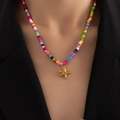 Detalle de collar bohemio de cuentas arcoíris con un colgante de estrella de mar dorada - Estrella De Mar (Collar Cuentas De Colores)
