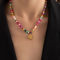 Primer plano de collar bohemio de cuentas coloridas con colgante de pez dorado en modelo - Pez (Collar Cuentas De Colores)