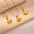 Detail of octopus pendants on gold necklace and earrings set over beige stone - Octopus Set