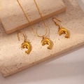 Detailed close-up of golden dolphin necklace and earrings set on elegant stone blocks - Dolphin Set
