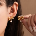 Elegant gold bow earrings with white pearl pendants showing worn and side views - Long Bow Pearl Drop (#1044)