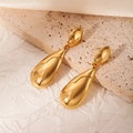 Macro detail of polished gold teardrop earrings on textured stone and paper base - All Golden Fluid Minimalist Water Drop Dangle Earrings (BJGE1049)