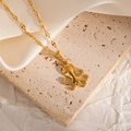 Detail of a polished golden octopus pendant necklace on a premium textured stone background - Squid