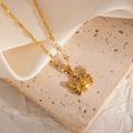 Macro shot of a golden crab pendant necklace resting on textured stone and silk - Crab