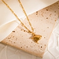 Close-up of golden crab pendant necklace with textured wave chain on silk fabric - Fish