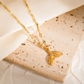 Detailed view of a golden crab pendant necklace on a stone surface with silk fabric - Mermaid Skirt