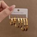 Primo piano di tre paia di orecchini a cerchio dorati in acciaio inossidabile di diverse misure - Stile a Cerchio (E1247) / Oro