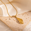 Golden 304 stainless steel conch pendant necklace on an elegant travertine display - Gold