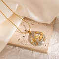 Macro shot of a gold necklace with a floral relief pendant on a beige satin background - Circular Floral Relief (JJN0166)