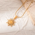 Collana con ciondolo a sole dorato e catena a serpente su sfondo di pietra ruvida - Raggi di Sole Minimalisti (JJN0052)