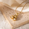 Macro detail of 18k gold floral pendant with three pearls on a sleek snake chain necklace - Three Flower Buds Style (JJN0082)