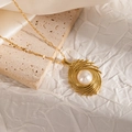 Detail of 18K gold plated heart pearl pendant necklace on a natural stone background - Radiant Spiral Line Style (JJN0086)